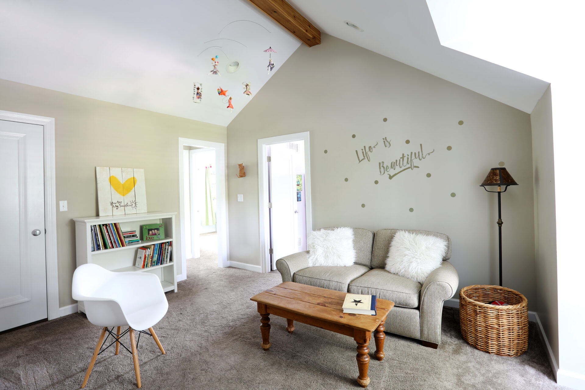 White vaulted ceiling with wood beam at peak in child's bedroom