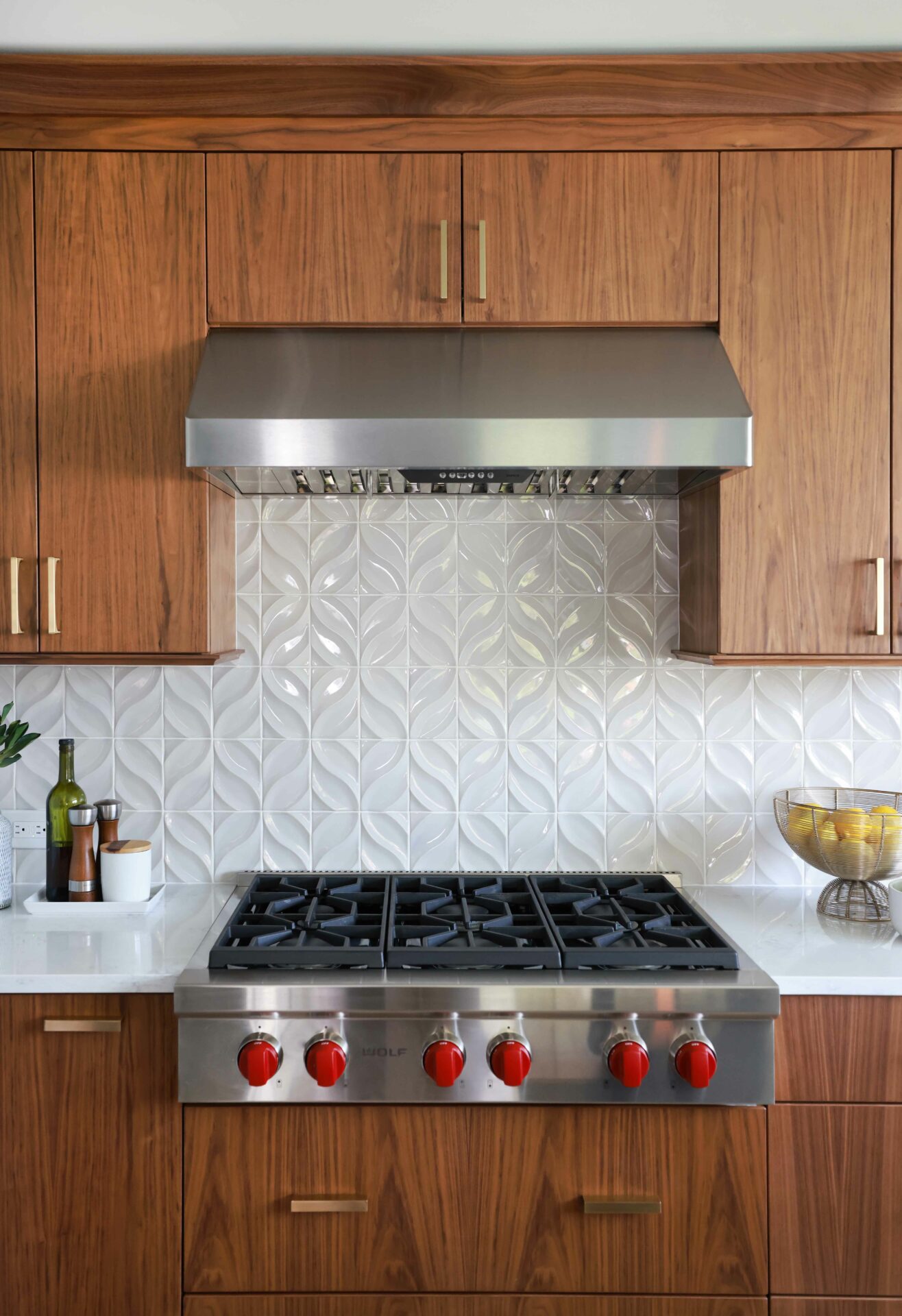 Walnut kitchen cabinets in a slab front with textured backsplash tile