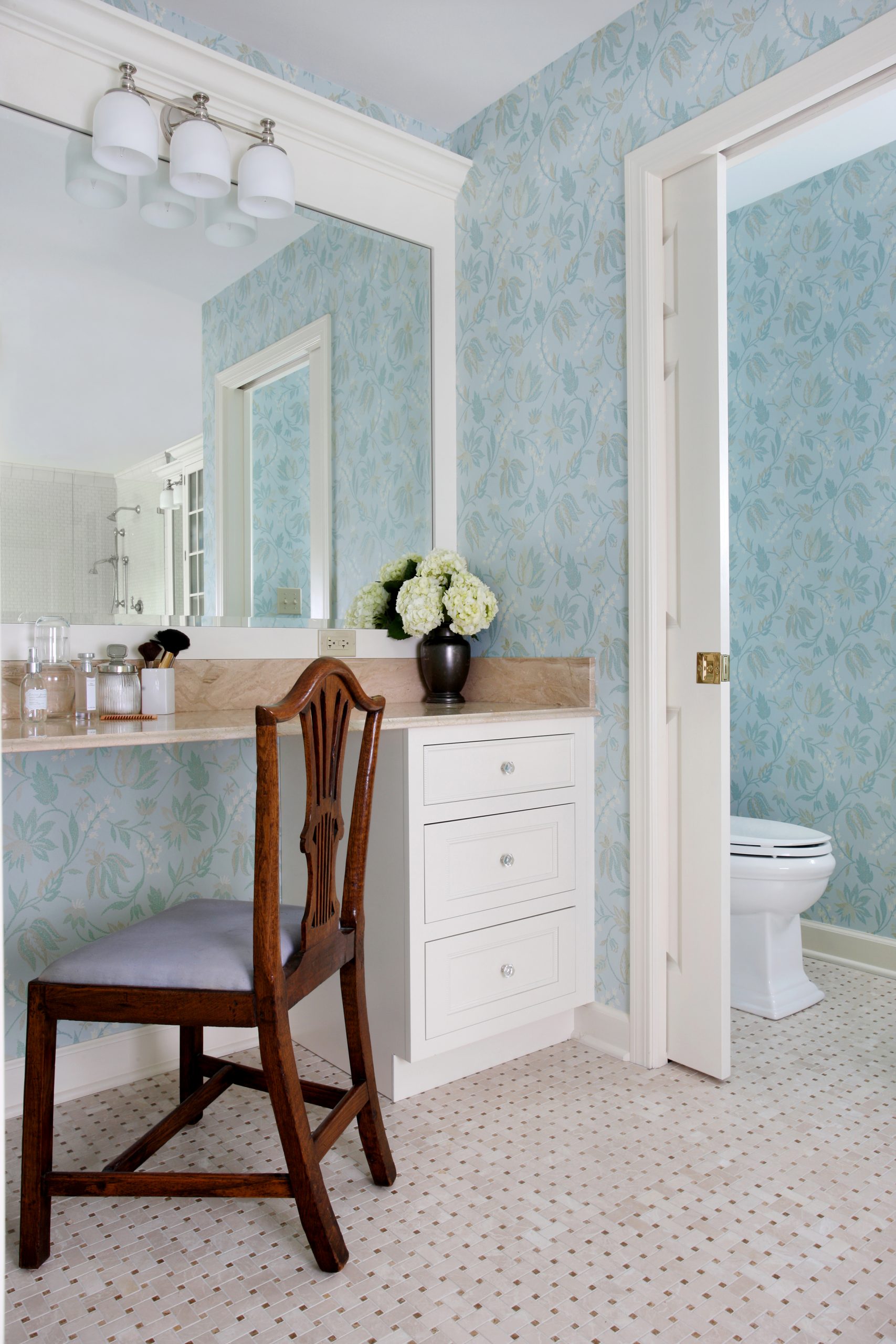 Table for makeup or dressing in bathroom looking into water closet